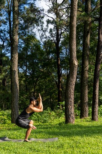 Young Hispanic practicing yoga in the forest