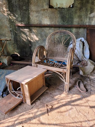 Old and broken wicker chairs and unwanted household stuff in an abandoned home