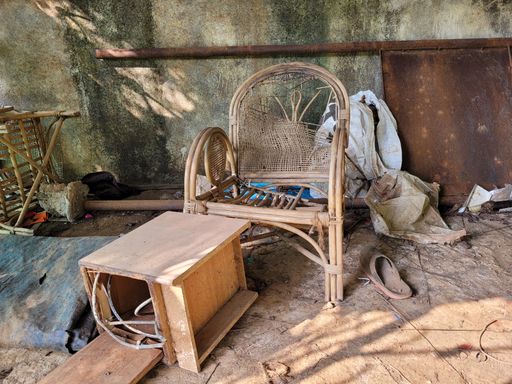 Old and broken wicker chairs and unwanted household stuff in an abandoned home