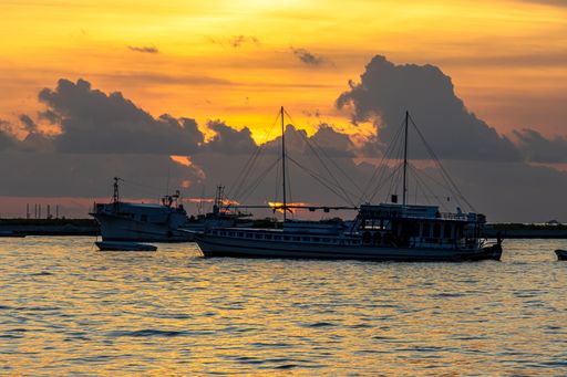Silhouette of boats with cloudy sunset sky background, in the Maldives.