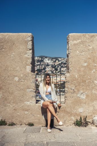 A vertical shot of a young Hispanic female posing on the Peniscola castle in Spain