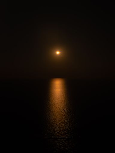 A mesmerizing view of the golden moon over the sea