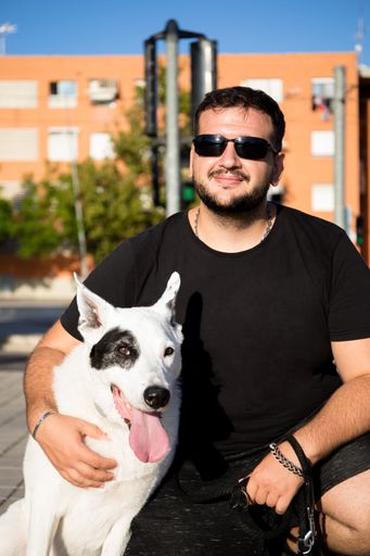 A vertical shot of a Caucasian male hugging his dog