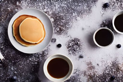 a top view of plates of pancakes with coffee on a side