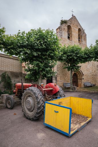 An old vintage red tractor parked at the garden