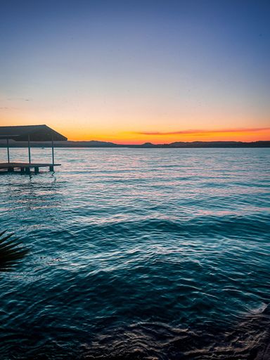 A lake with reflections during sunset