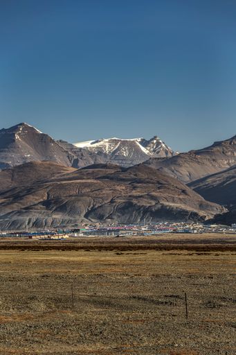 A vertical shot of the Taqin County and a mountain with snowy peak in Ali Prefecture, Tibet, China