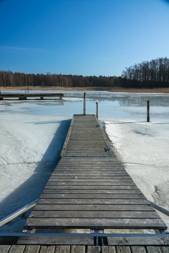 A vertical shot of the narrow jetty leading to the frozen water in Tammisaari, Finland
