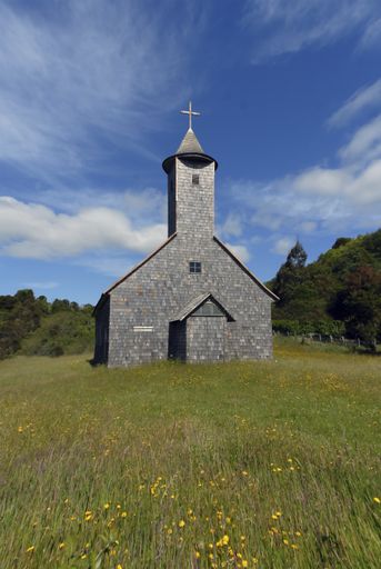 A beautiful view of a small church surrounded by green trees