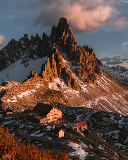 An aerial view of snow covered mountain landscape during sunset
