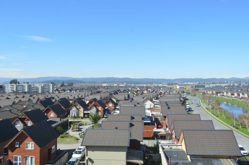 An aerial shot of the small houses with similar structure and roof in a beautiful town