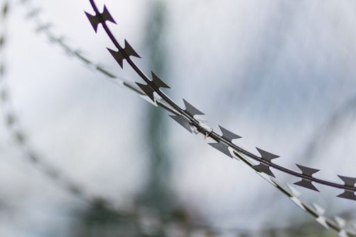 A selective focus shot of a security fence wires