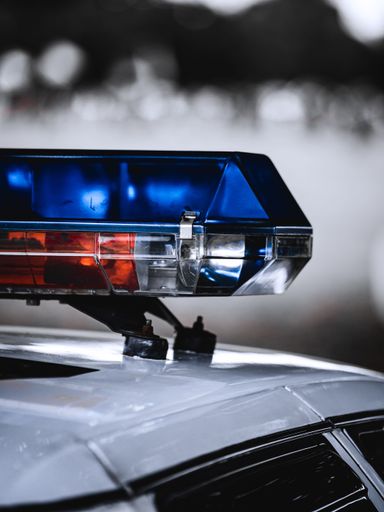 A vertical closeup of a police car emergency light siren