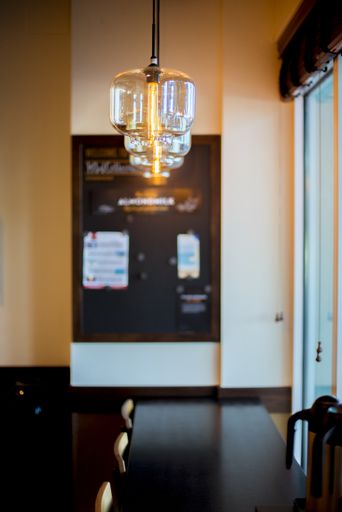 A vertical interior shot of a cafe lights hanging from the ceiling with a blurred background