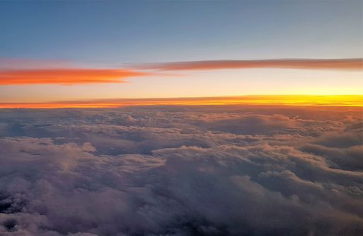 A breathtaking view of beautiful white clouds seen from above at sunset
