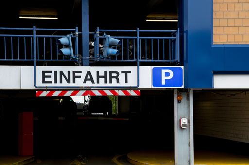 Entrance of a car parking garage signal lights and the sign "Einfahrt"