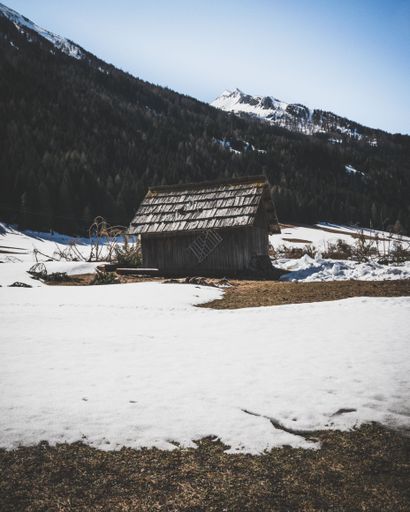 A small wooden hut in snowy valley between the Alps in Austria