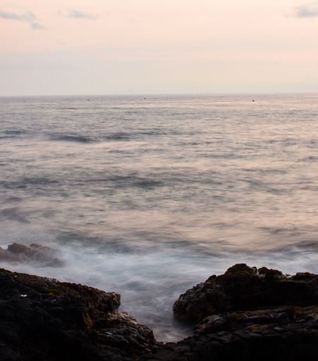 The calm waves on a beach in Hawaii during sunset