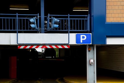 Entrance of a car parking garage with signal lights and a blank sign