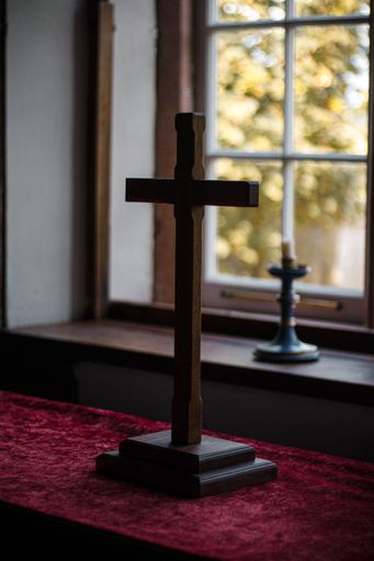 A vertical shot of a wooden cross laid on the table