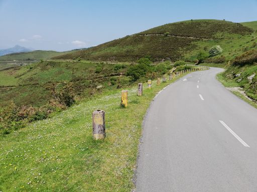 A winding road leading through a green lush hills
