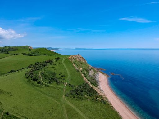 An aerial view of a beautiful beach and green island under a blue sky
