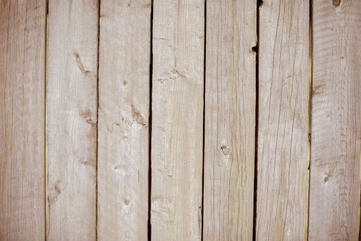 A closeup shot of a fence made of vertical brown wooden planks - perfect for a cool wallpaper background