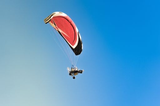 A person parasailing in the blue sky
