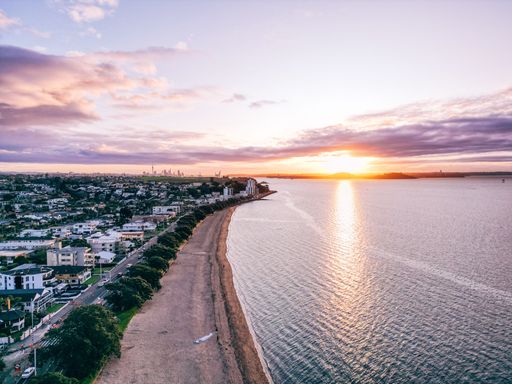 A beautiful view of a town with houses and a calm sea during sunset