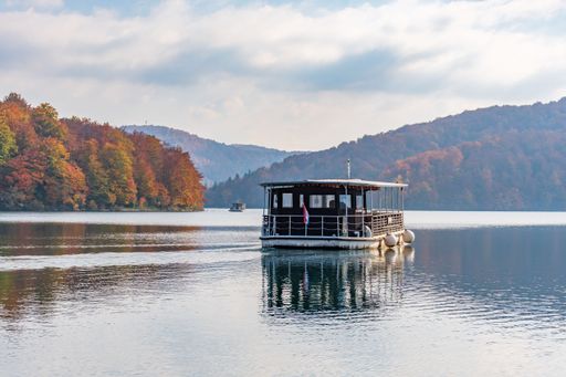 A beautiful landscape of the autumn forest at the shore of a lake with a boat