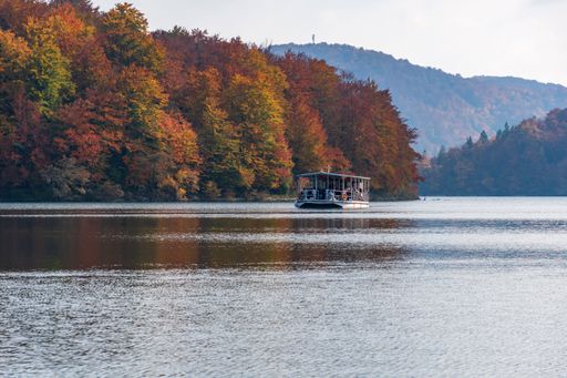 A beautiful landscape of the autumn forest at the shore of a lake with a boat