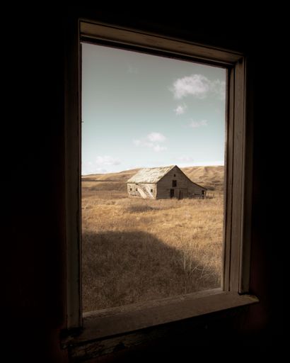 An abandoned barn is seen from a window in the Albertan Badlands, Canada