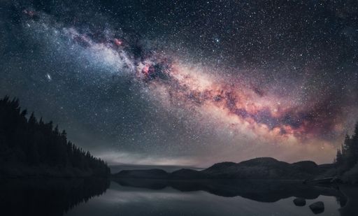 A beautiful shot of the Milky Way illuminating a dark night sky above a lake in Quebec, Canada