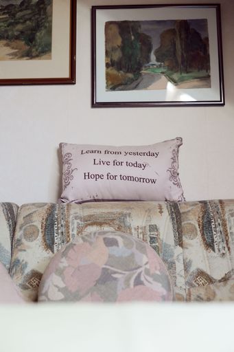 A vertical shot of a living room sofa with a motivational quote pillow