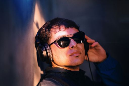 A Caucasian man wearing glasses and headphones
