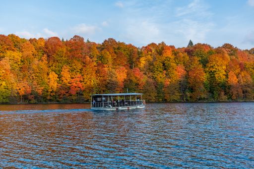 A beautiful landscape of the autumn forest at the shore of a lake with a boat