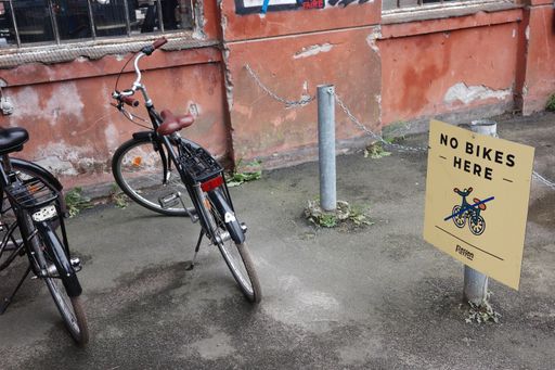 A closeup of bikes parked by "No bikes here" sign