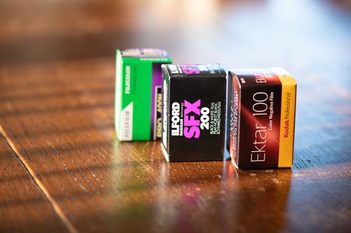 The boxes of 35mm films for Analog Photo Cameras on wooden table