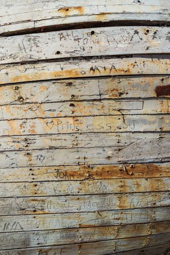 A vertical shot of an old wood with writings on it