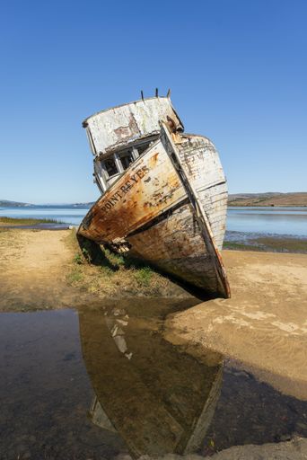 A vertical closeup of an old rusty ship in Tomales Bay in California