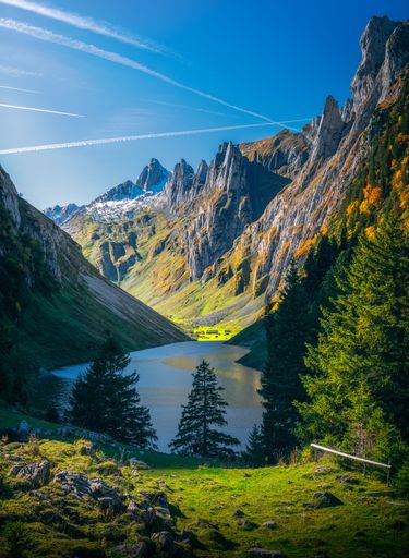A vertical shot of a lake in between mountains on a sunny day