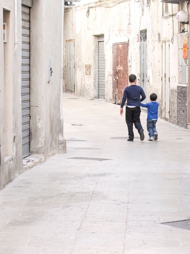 A view of two young boys holding hands on a street