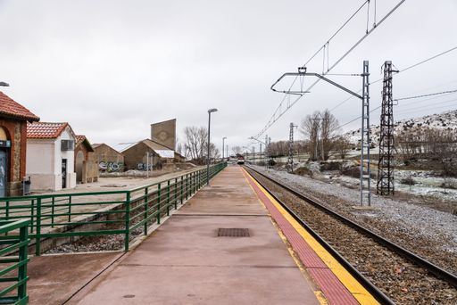 Perspective railway and train station in snowed landscape in the countryside