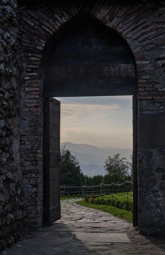 A vertical shot from a doorway with the view of a road and hills in the background