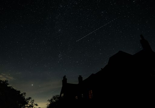 A beautiful view of a starry sky over the buildings silhouettes