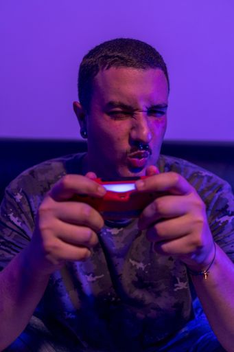A shallow focus shot of a young male playing with a gaming controller