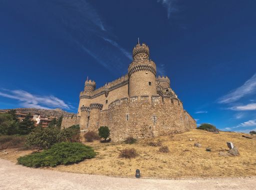 A low angle shot of the Castle Manzanares el Real in Madrid, Spain against a blue sky