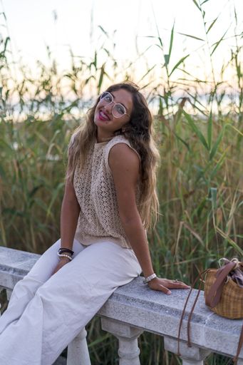A vertical shot of a young lady with beautiful long hair happily posing for a photo