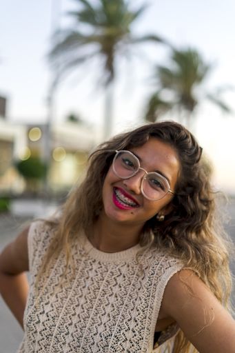 A vertical shot of a young lady with beautiful long hair happily posing for a photo