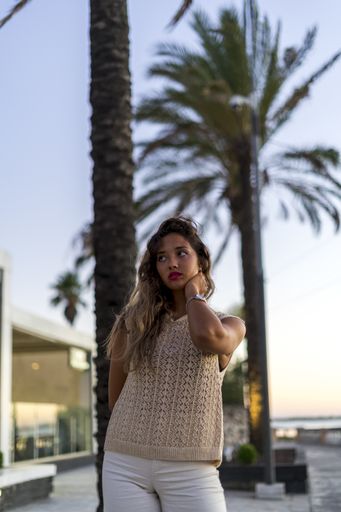 A vertical shot of a young lady with beautiful long hair happily posing for a photo